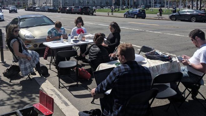 Люди сидят за столом на парковке