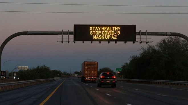 A freeway sign reads 'stay healthy, stop Covid-19, mask up AZ'