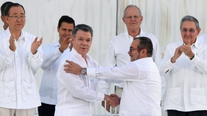 На этом файле, сделанном 26 сентября 2016 года, изображены президент Колумбии Хуан Мануэль Сантос (слева в центре) и глава партизанского отряда ФАРК Тимолеон Хименес, он же Тимоченко, во время подписания исторического мирного соглашения между правительством Колумбии и Революционными вооруженными силами. Колумбии (FARC), в Картахене.