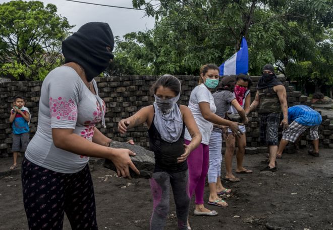 Женщины и девочки строят баррикаду в Манагуа после нападения, совершенного несколько часов назад полицией и военизированными формированиями
