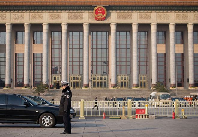 Полицейский стоит на страже у Большого зала народа перед открытием нового Постоянного комитета Политбюро в Пекине 15 ноября 2012 года.