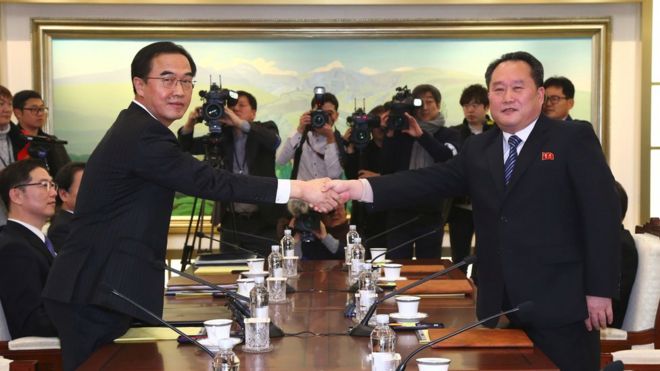 Министр объединения Южной Кореи Чо Мен Гюн (слева) обменивается рукопожатием с главным делегатом Северной Кореи Ри Сон Гуоном (справа) во время их встречи в деревне пограничного перемирия Панмунжом в демилитаризованной зоне (ДМЗ), разделяющей две Кореи 9 января, 2018