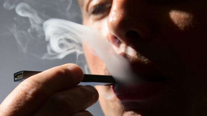 На этой иллюстрации, сделанной 2 октября 2018 года, мужчина выдыхает дым из электронной сигареты в Вашингтоне, округ Колумбия.