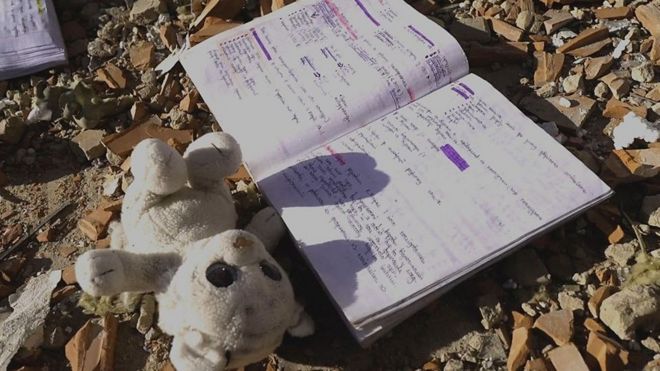 Игрушка и тетрадка на земле