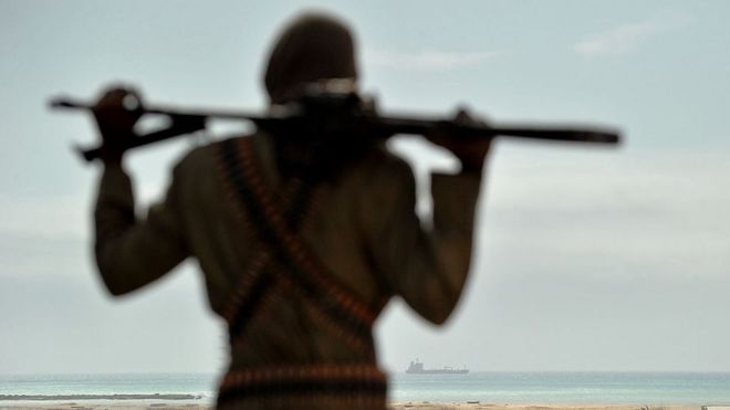 Мохамед Гарфанджи, главный пиратский босс Сомали, стоит на песчаных дюнах недалеко от центрального сомалийского прибрежного города Хобьо, наблюдая за контуром угнанного корабля, стоящего на якоре у берега 20 августа 2010 года