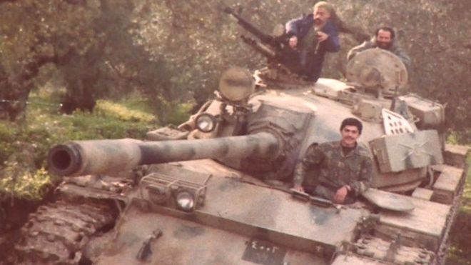 Бадри изображен среди трех человек на танке во время гражданской войны в Ливане
