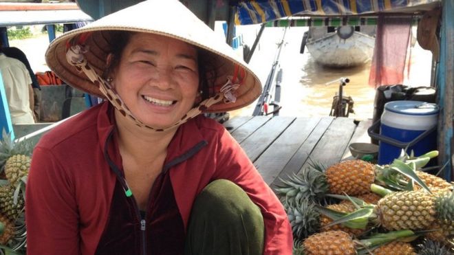 Bin Thui является продавцом фруктов на плавучем рынке фруктов и овощей в Кай Ранг недалеко от Кантхо во Вьетнаме в августе 2015 года.