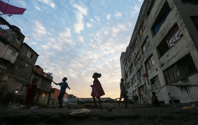 9 августа 2016 года дети высаживают детей возле занятого здания в сообществе фавелы в Мангейре