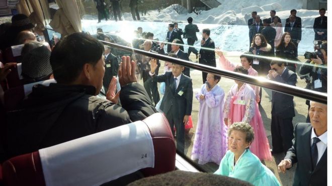 In a file photo taken on 22 February 2014 a South Korean man (L) waves to his North Korean relatives from the window of a bus following a family reunion at the resort area of Mount Kumgang, North Korea