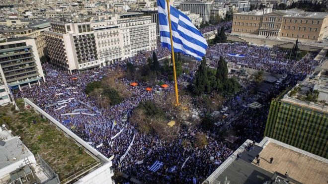 People hold Greek flags as they demonstrate to urge the government not to compromise in the festering name row with neighbouring Macedonia, at the Syntagma Square in Athens, on February 4, 2018