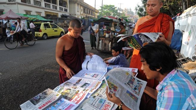Группа мужчин читает газеты в столице Мьянмы Янгоне в 2014 году
