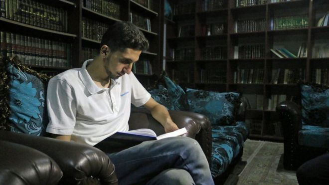 Joven leyendo en la biblioteca secreta de Siria.