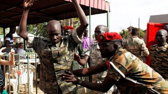 Солдат Южного Судана проверяется, когда он прибывает для вынесения приговора за изнасилование иностранных работников по оказанию помощи и убийство местного журналиста в ходе нападения на гостиницу Terrain в столице Джуба в 2016 году в военном суде в Джубе, Южный Судан, 6 сентября. 2018.