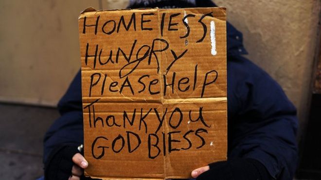 Бездомный держит знак