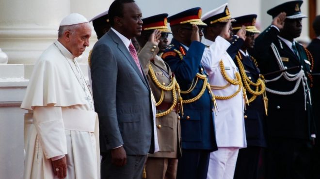 Папа Фрэнсис (слева) и президент Ухуру Кениата (2-л), исполняющие государственный гимн, по прибытии в Государственный Дом в Найроби, Кения, 25 ноября 2015 года