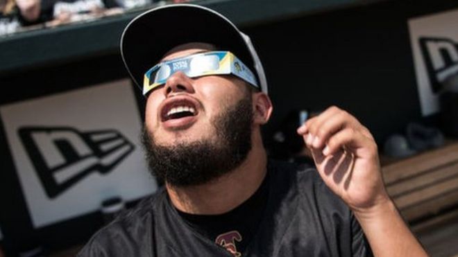 Beisbolistas mirando el eclipse.