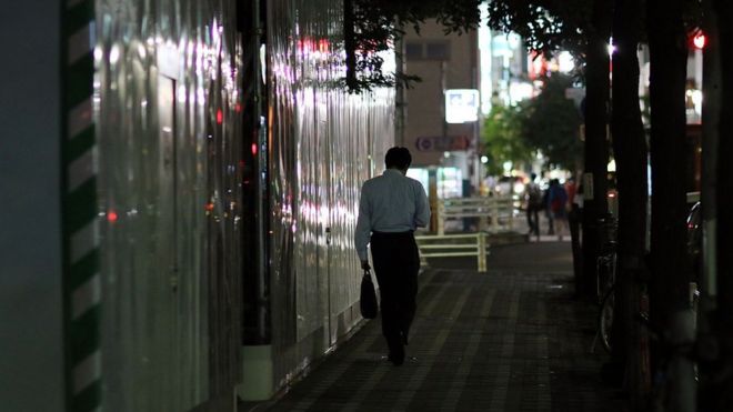 Бизнесмен идет по улице в Токио