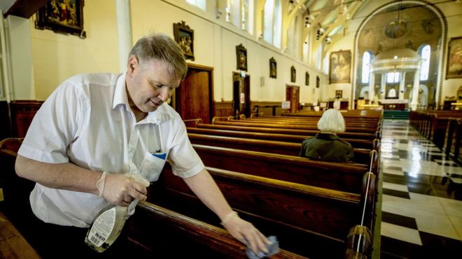 Член церкви убирается в церкви Святой Марии в Белфасте после того, как в прошлом месяце он был открыт для публики