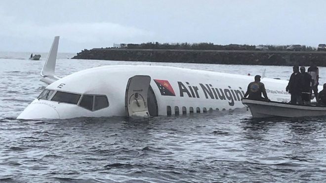 местные жители приближаются к разбившемуся самолету Air Niugini на отдаленном острове Вено, в Микронезии.