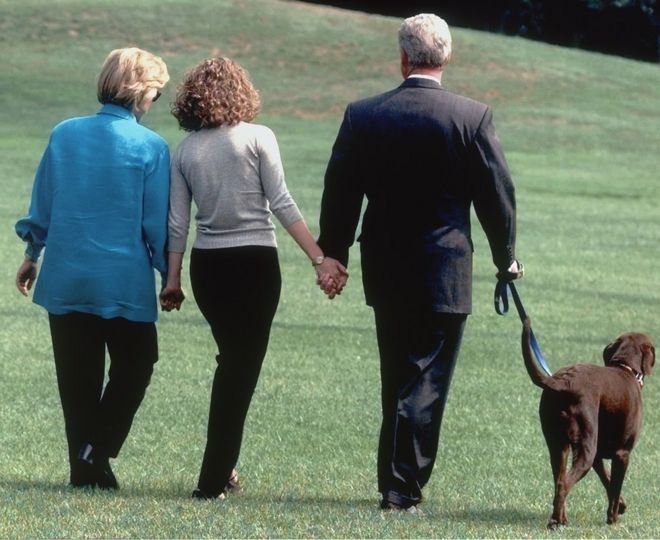 Президент Клинтон, его дочь Челси (в центре) и жена Хиллари идут с Бадди во вторник, 18 августа 1998 года, из Белого дома к вертолету, когда они отправляются в отпуск по пути к винограднику Марты