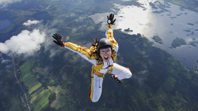 Mujer con paracaídas saltando de un avión