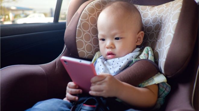 صورة أرشيفية لطفل يستخدم شاشة داخل سيارة