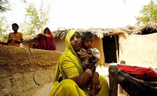 На этом снимке, сделанном 04 мая 2007 года, индийский недоедающий ребенок, Виру (R), утешает свою мать возле своей хижины в деревне в районе Шивпури, примерно в 113 км от Гвалиора.