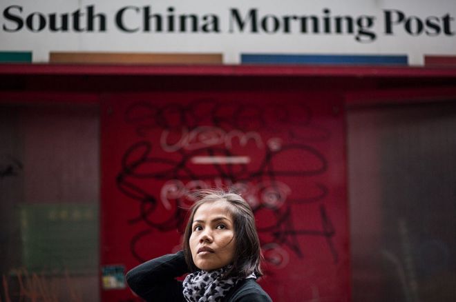 Женщина проходит мимо Южного Китая Morning Post знак