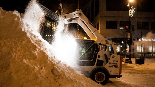 Un cargador frontal removiendo nieve en la calle