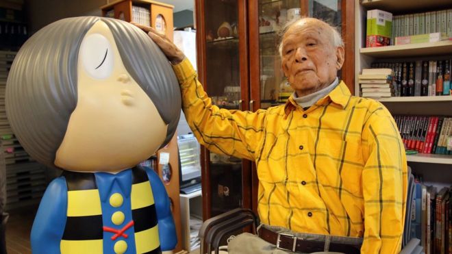 Japanese 93-year-old comic artist Shigeru Mizuki sitting next to his famous character "Kitaro"