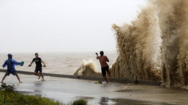 Жители играют волнами в Апарри, провинция Кагаян, после тайфуна Мангхут, 15 сентября 2018 г.