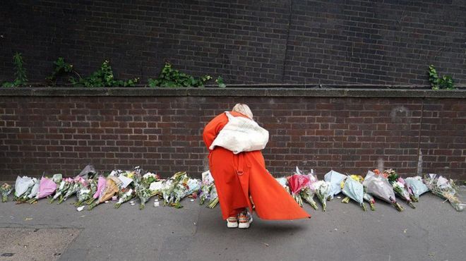 امرأة تضع الزهور بالقرب من مكان الحادث في كرويدون، جنوب لندن