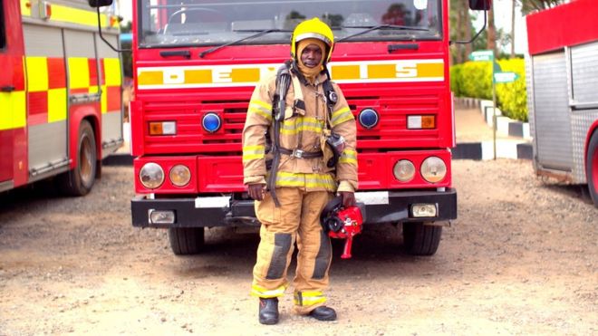 Кенийский пожарный перед пожарной машиной