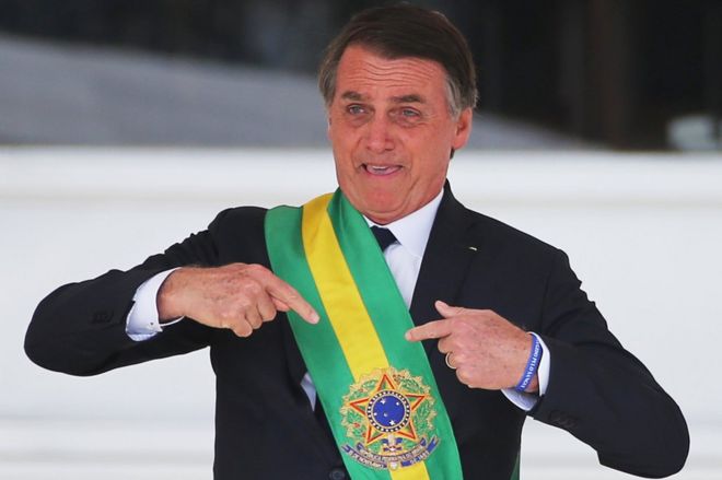 Жаир Больсонаро жестикулирует после получения президентской створки от бывшего президента Мишеля Темера во дворце Планалто, в Бразилиа, Бразилия, 1 января 2019 года