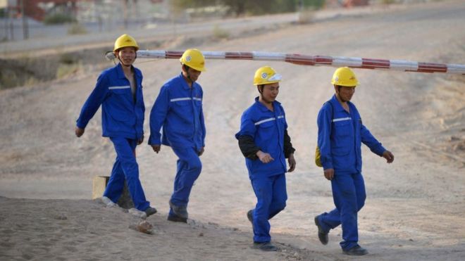 На этом снимке, сделанном 23 мая 2018 года, изображены китайские рабочие, идущие на поддерживаемой Китаем электростанции, строящейся в Исламкоте в пустыне Тарпаркар, в южной части пакистанской провинции Синд