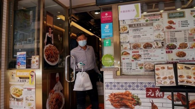 Мужчина получает еду на вынос из ресторана Гонконга