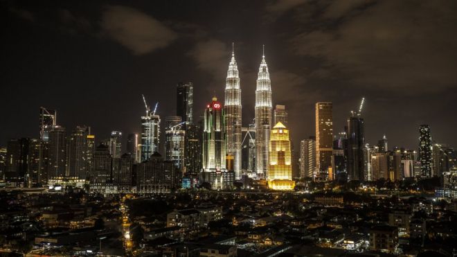 A view of the Petronas Towers (C) with light on before Earth Hour in Kuala Lumpur, Malaysia