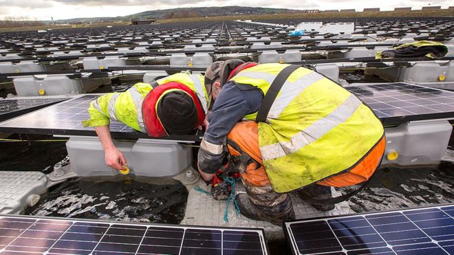 мужчины, устанавливающие солнечные батареи