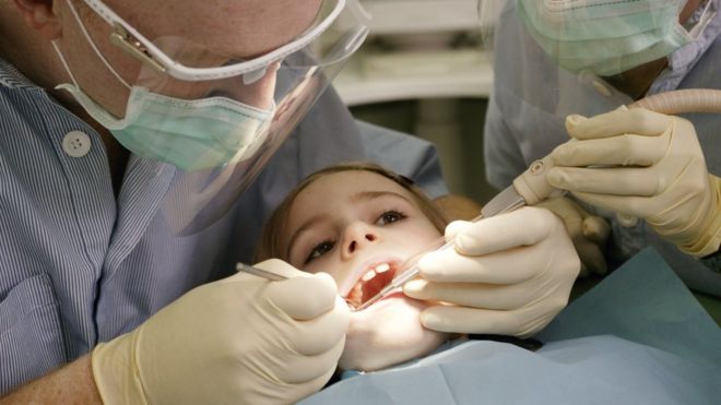 Ребенка осматривает стоматолог
