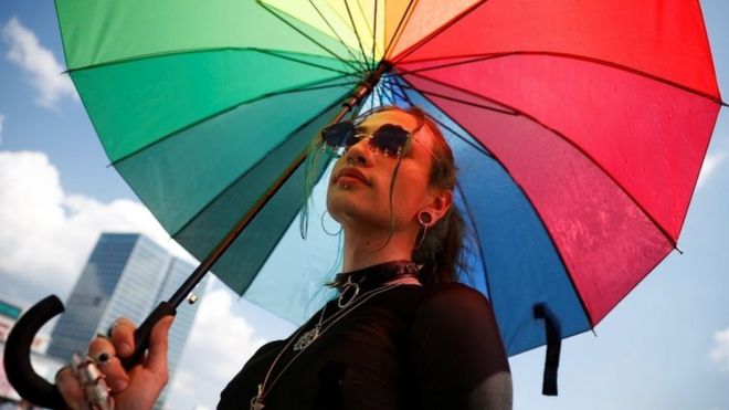 Protester holds rainbow umbrella during Warsaw pride march