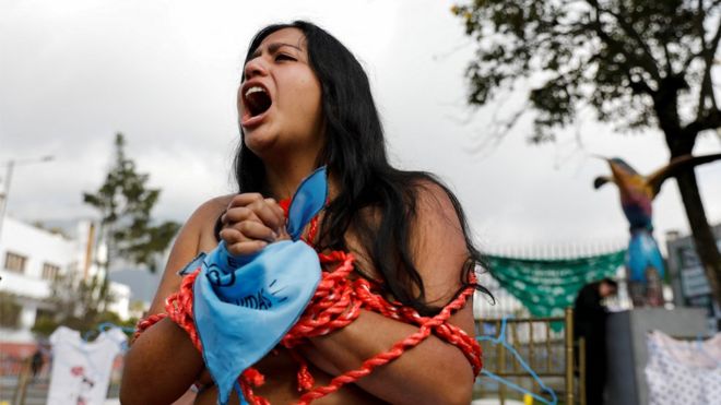 Una activista grita frente a la sede de la Asamblea Nacional de Ecuador en Quito