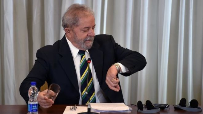 Бывший президент Бразилии Луис Инасиу Лула да Силва смотрит на свои наручные часы перед началом пресс-конференции в Сан-Паулу, Бразилия, 28 марта 20 года.
