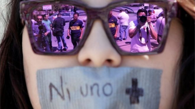 Journalists are reflected on the sunglasses of a woman during a protest in Ciudad Juarez against the murder of the journalist Miroslava Breach. The strap reads "Not one more" (25/03/2017)