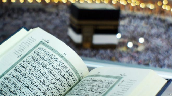 Мусульманин-пилигрим читает Коран в Большой мечети в Мекке, Саудовская Аравия, на заднем плане - Кааба 9 ноября 2010 года