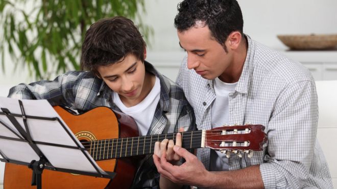 Учитель игры на гитаре Bark помогает мальчику освоить инструмент