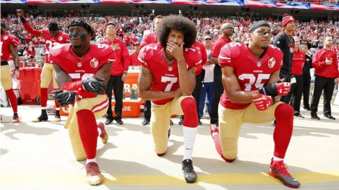 (L-R) Eli Harold, Colin Kaepernick and Eric Reid kneeling in protest during the American national anthem