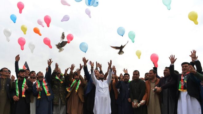 Youth release balloons and pigeons as they celebrate the reduction in violence, in Jalalabad on 28 February