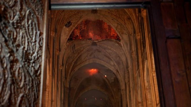 Пламя и дым поднимаются изнутри собора Нотр-Дам в Париже 15 апреля 2019 года