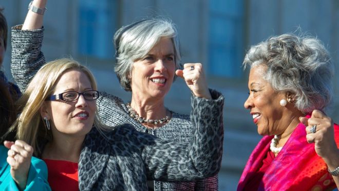 Слева направо, член палаты представителей Кирстен Синема, штат Аризона, член палаты представителей Кэтрин Кларк, штат Массачусетс, и член палаты представителей Джойс Битти, штат Огайо, поднимают кулаки во время возможности сфотографироваться с демократическими женщинами Палаты представителей, среда, январь 4, 2017,