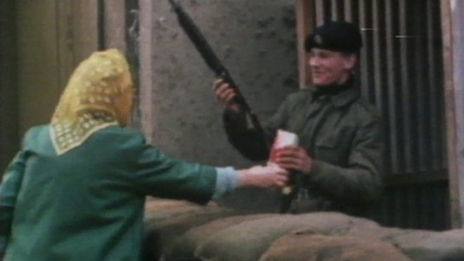 Солдат принимает пачку печенья от женщины в Белфасте